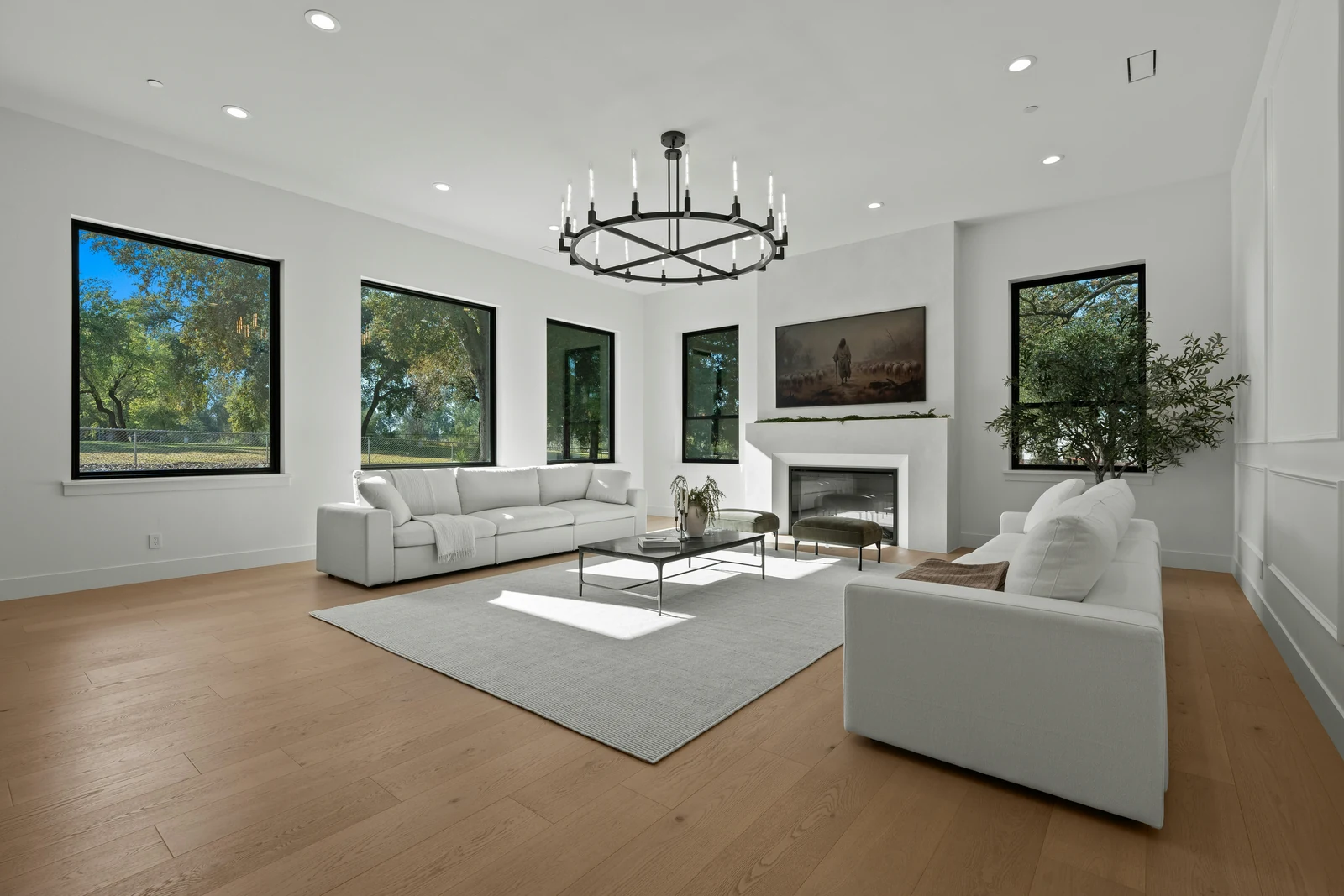 Reference photo of a living room with large windows, light wood flooring and a white sofa